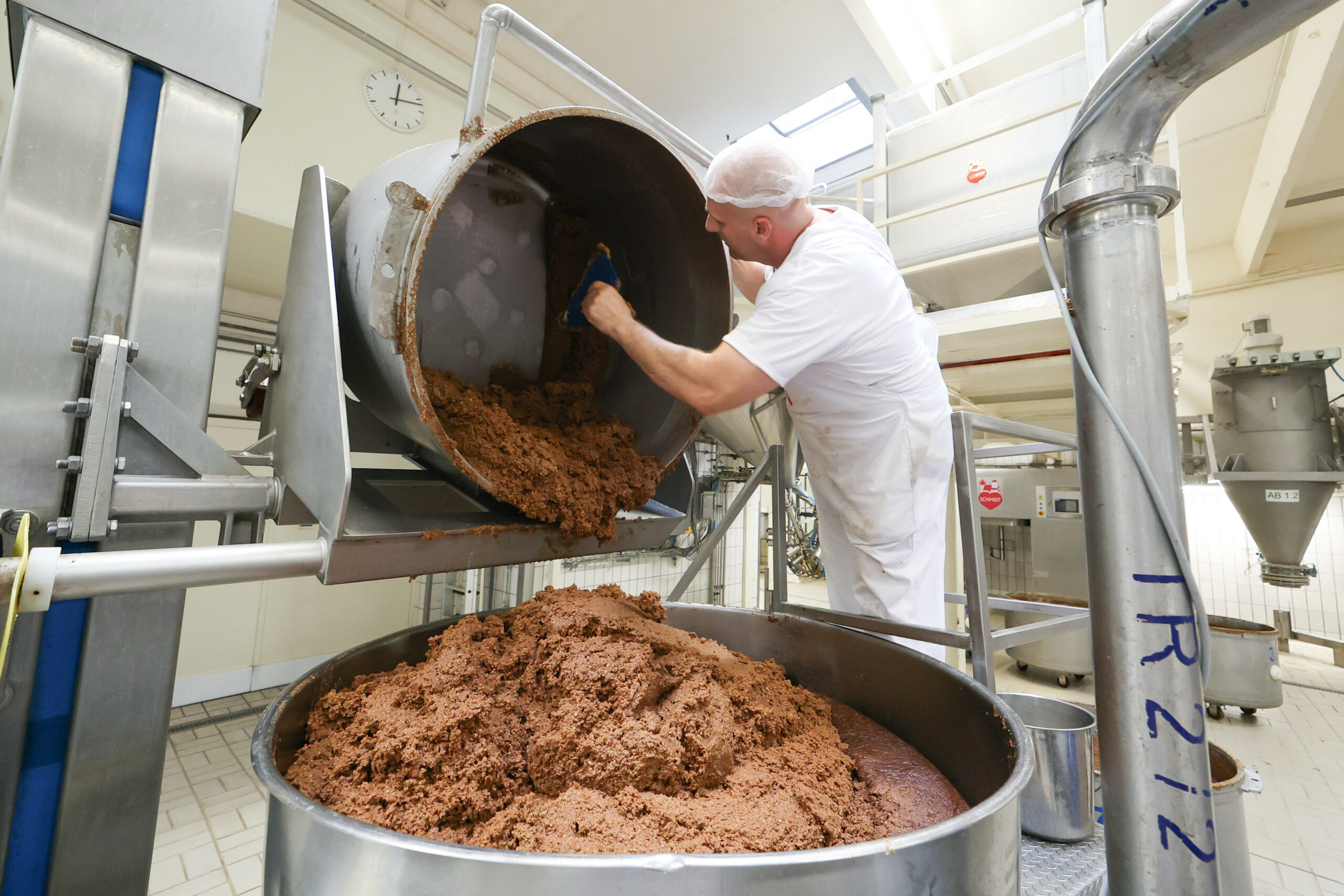 Lebkuchenmasse wird aus einem Behälter in der Produktion des Lebkuchenherstellers Schmidt in den Behälter eines Streichautomats umgefüllt.