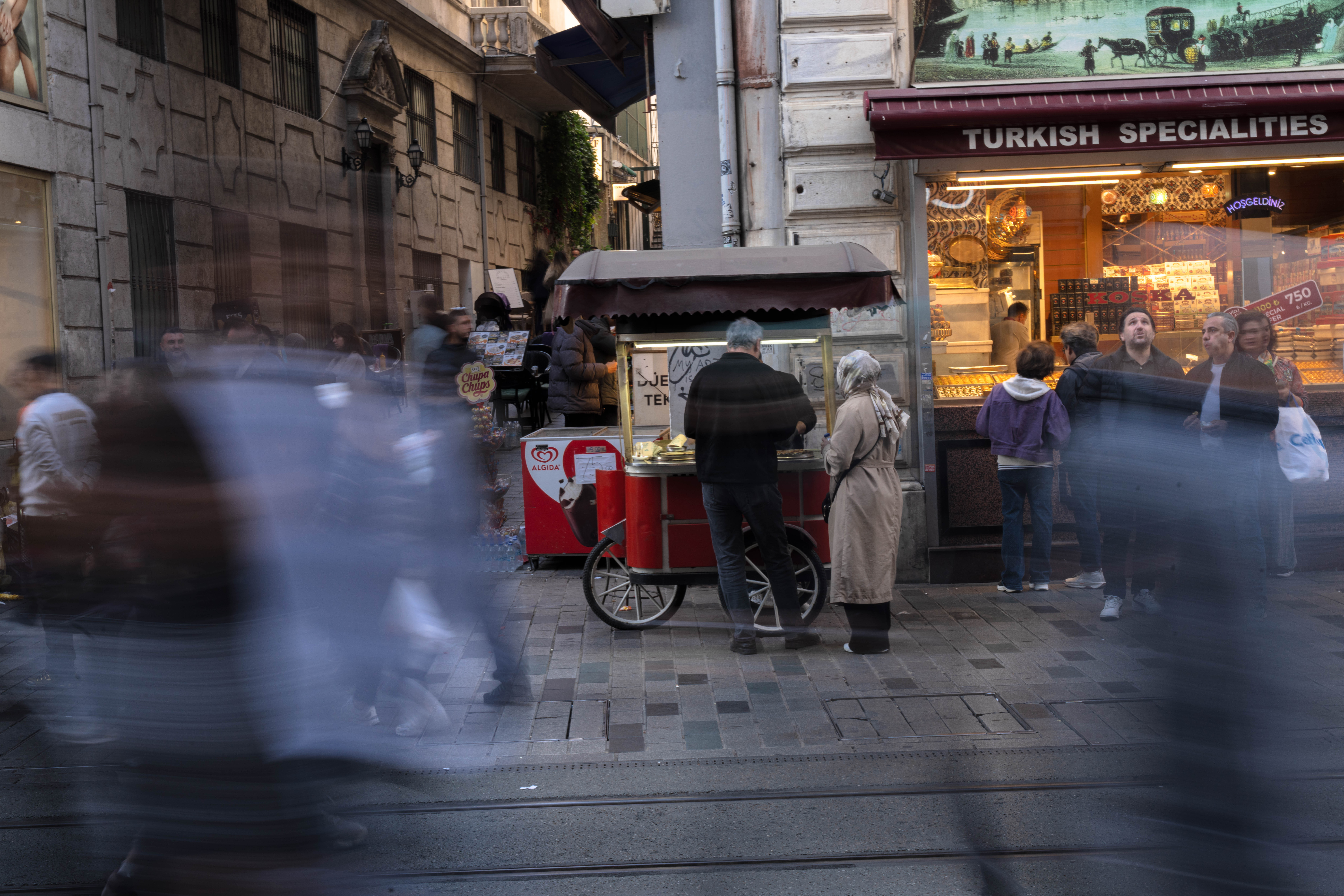 Menschen gehen an einem Imbissstand auf der Istiklal-Straße vorbei, einer belebten Fußgängerzone in Istanbul (Symbolfoto).