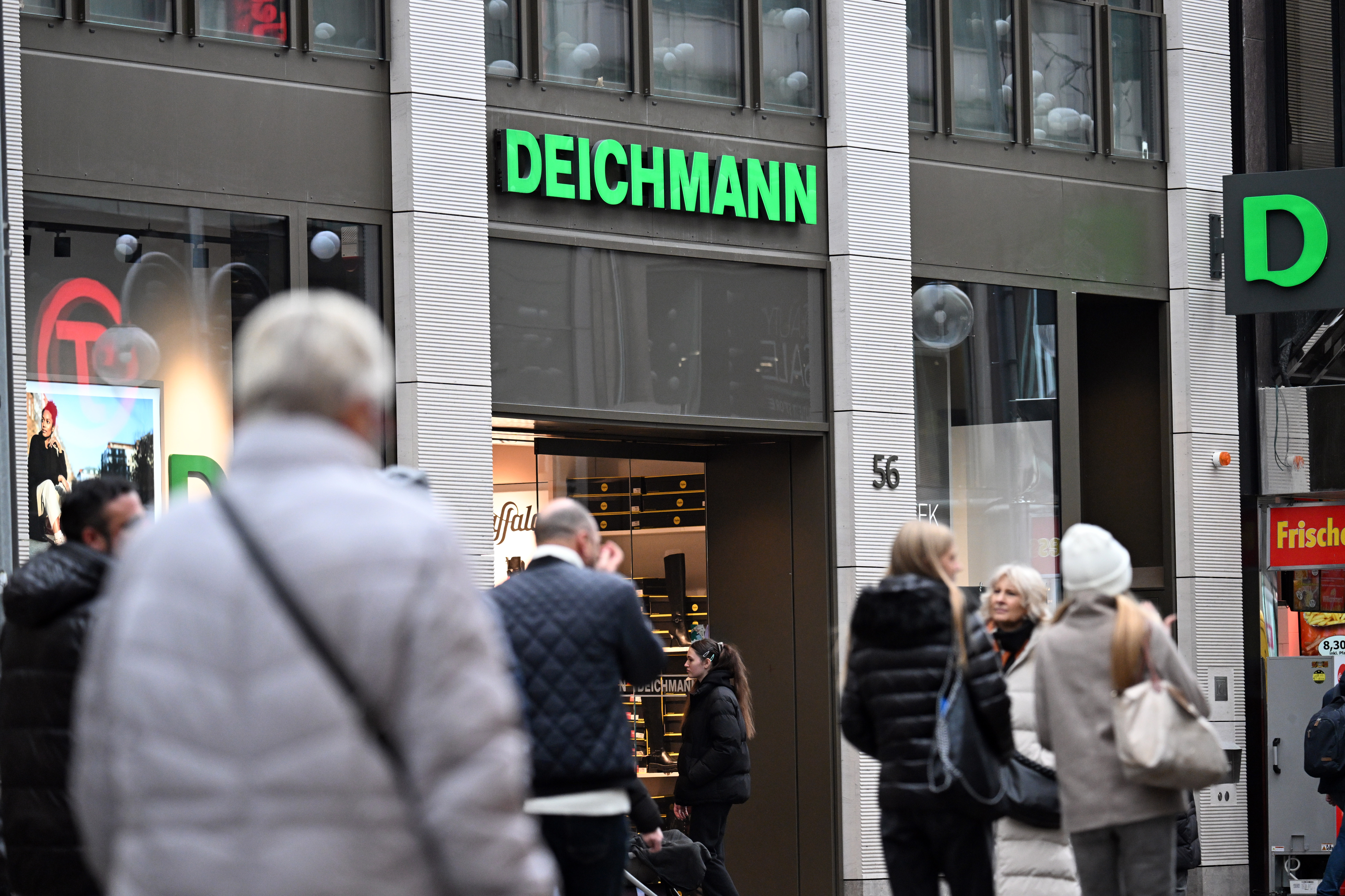 Passanten gehen an einer Deichmann-Filiale vorbei.