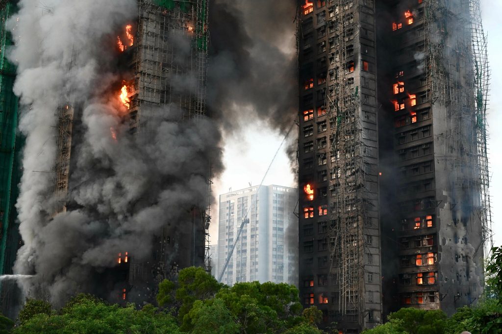 Nähere Aufnahme auf zwei brennende Gebäude. Man sieht Feuer in mehreren Stockwerken.
