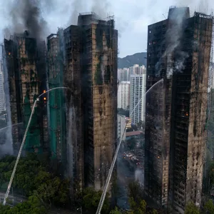 Auch am Morgen nach dem Großbrand in Hongkong ist die Feuerwehr weiter im Dauereinsatz.