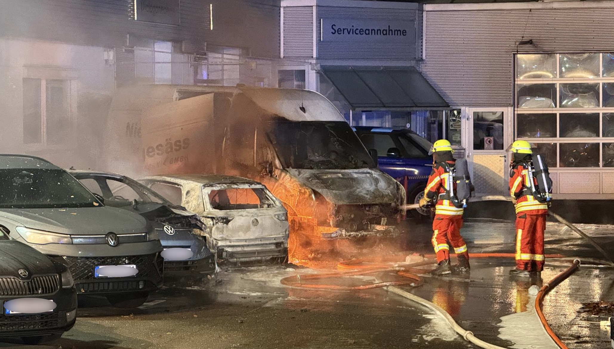 Feuerwehrleute löschen die brennenden Fahrzeuge in Kaltenkirchen.