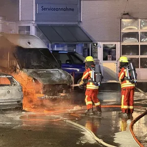 Feuerwehrleute löschen die brennenden Fahrzeuge in Kaltenkirchen.