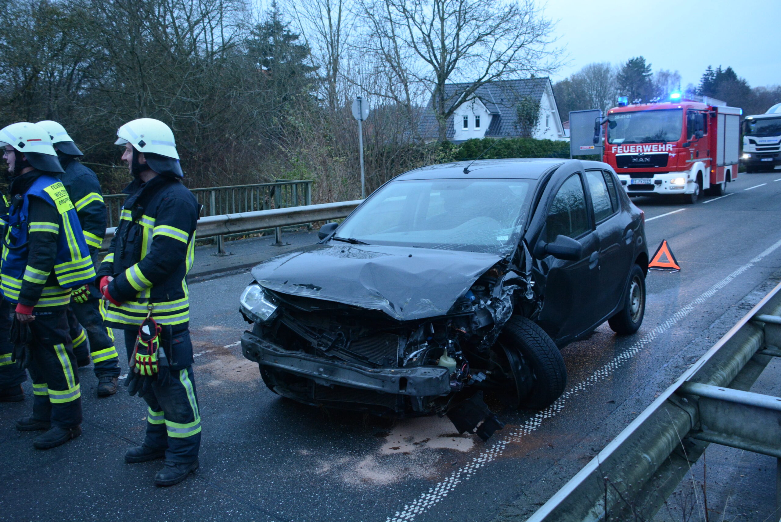 Feuerwehrkräfte stehen vor einem verunfallten Auto.