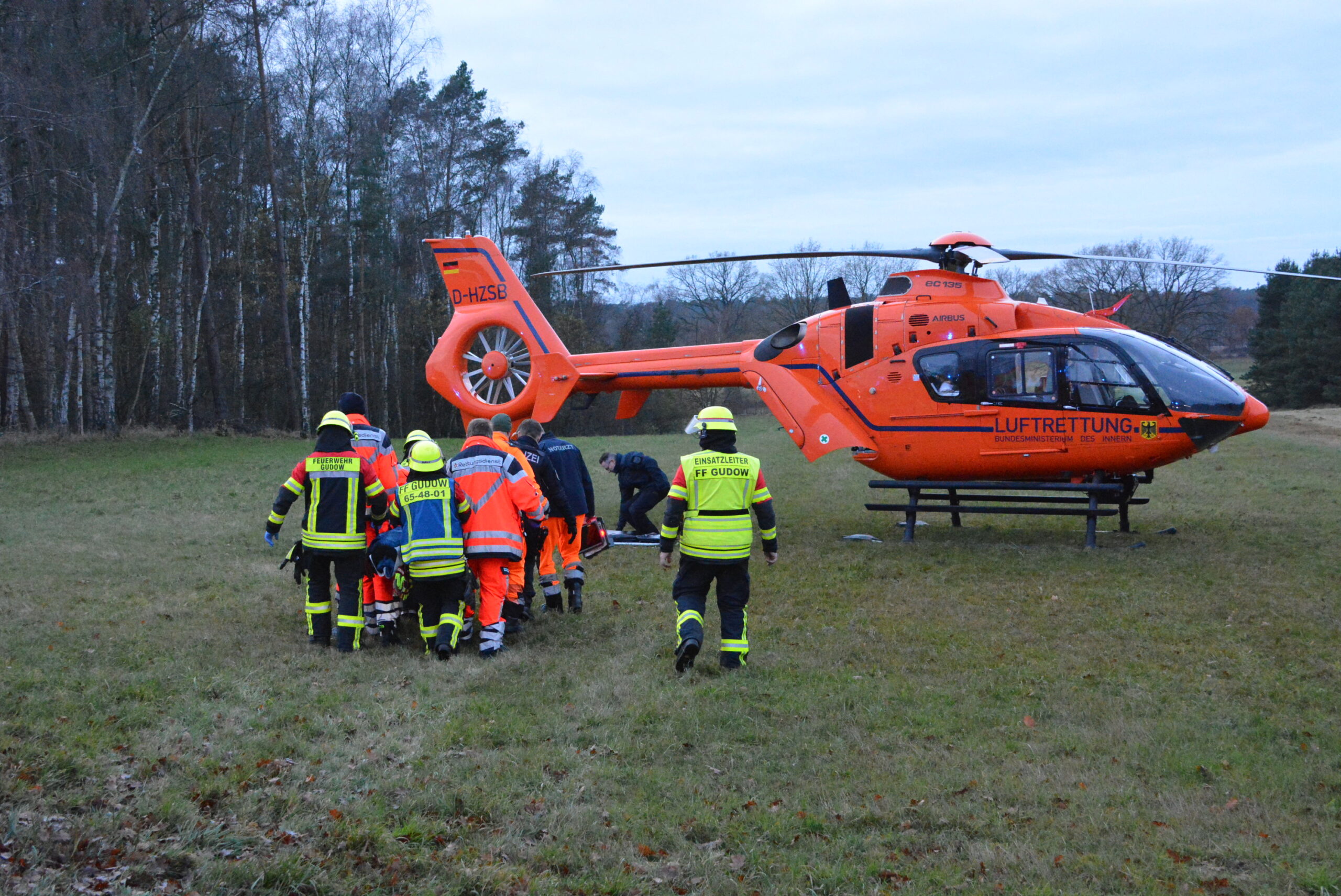 Einsatzkräfte vor einem Rettungshubschrauber