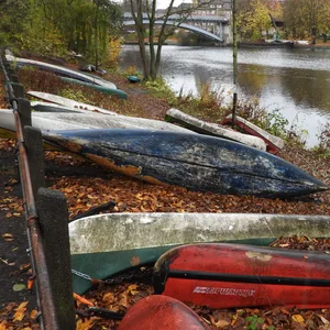 Alte Kanus liegen am Ufer der Alster.