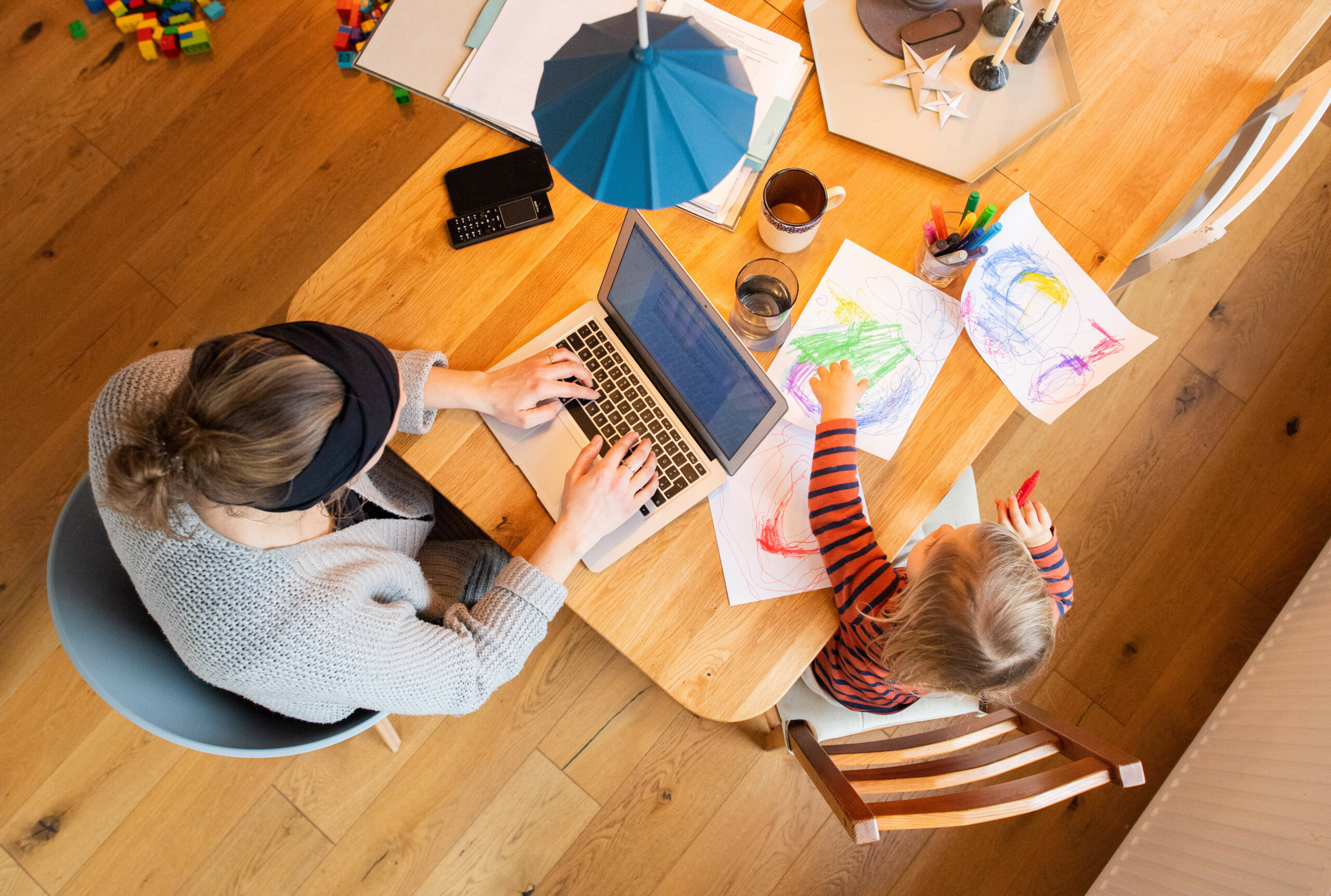 Eine Frau arbeitet im Homeoffice mit Kind.