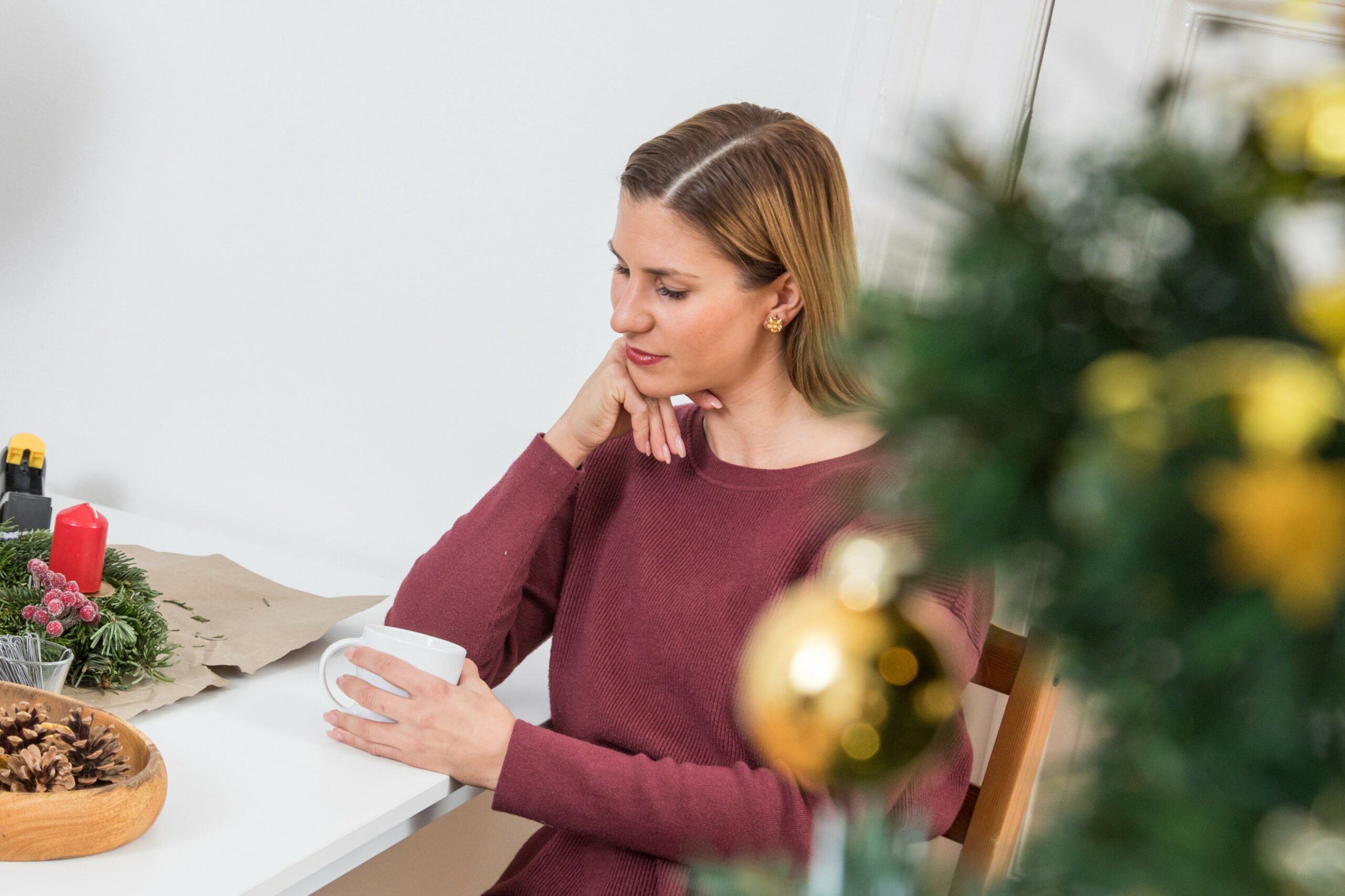 Eine Frau genießt mit einer Tasse Tee die stillen Weihnachtsmomente.