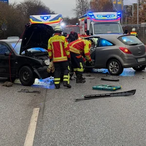 Mehrere Einsatzkräfte stehen an den zwei beschädigten Autos.