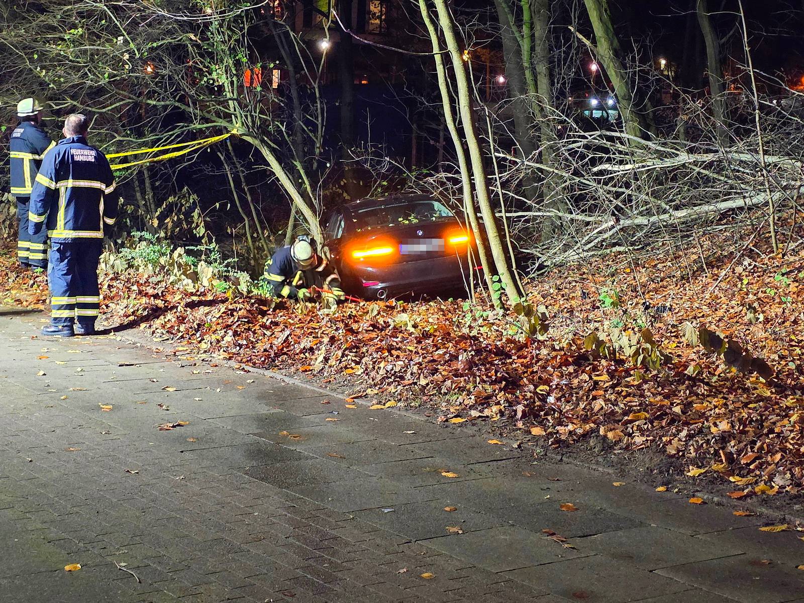 Feuerwehrkräfte begutachten den BMW.