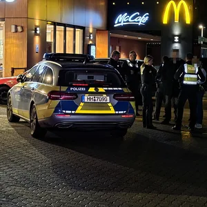 Ein Polizeiwagen steht vor einer McDonald‘s-Filiale.