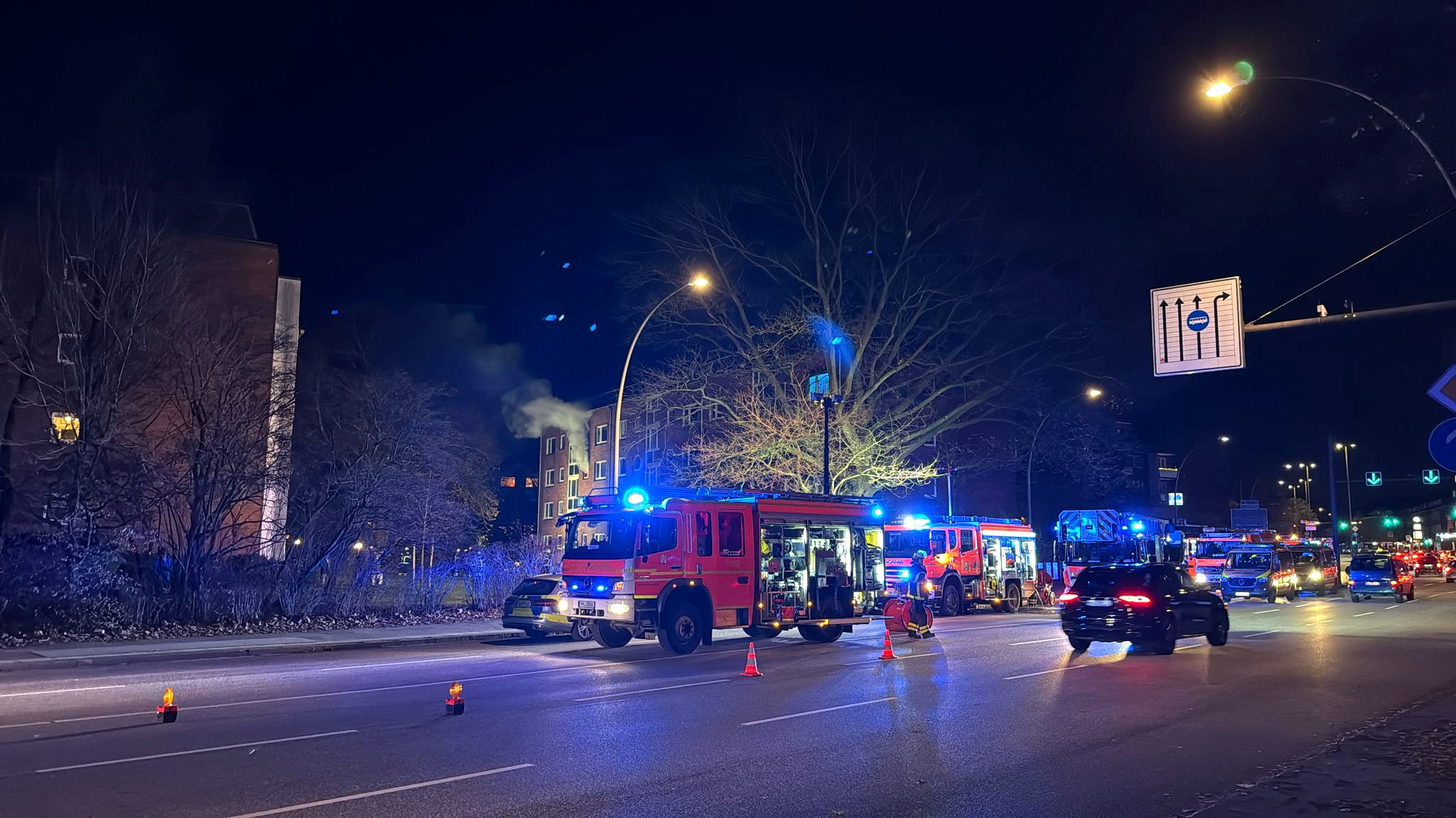 Feuerwehr vor einem Haus, aus dem Qualm dringt