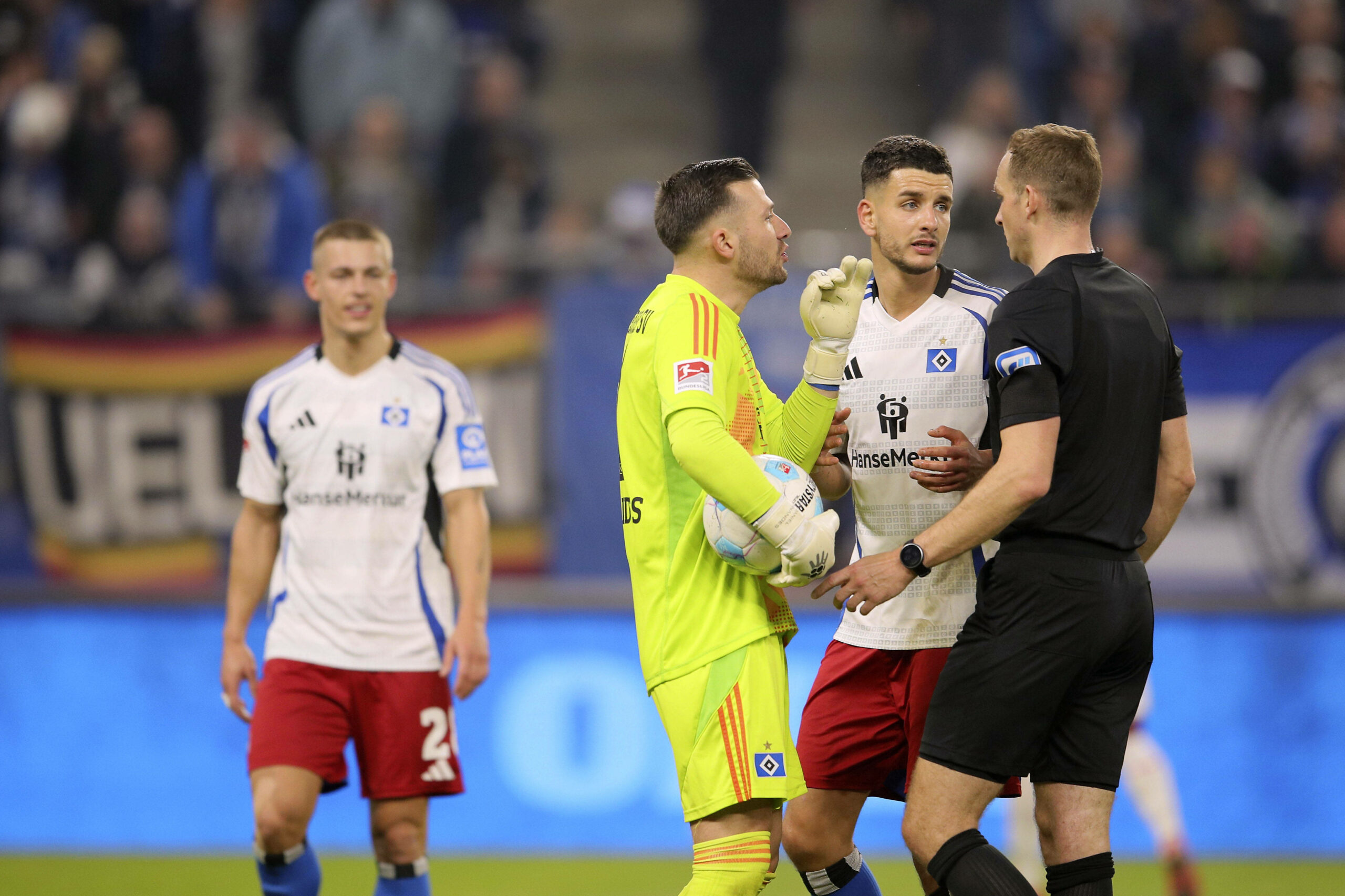 Daniel Heuer Fernandes und Daniel Elfadli diskutieren mit Schiedsrichter Sören Storks.