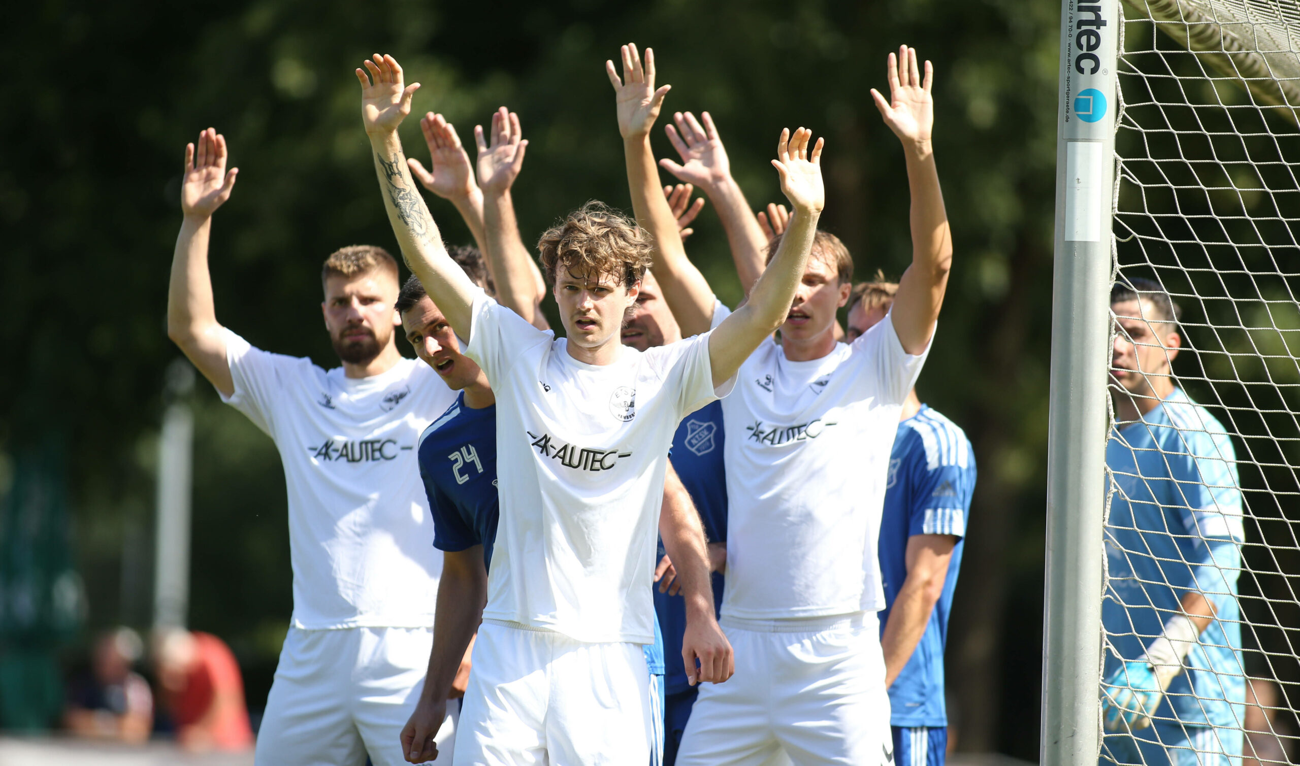 Spieler des ETSV Hamburg heben die Arme nach oben