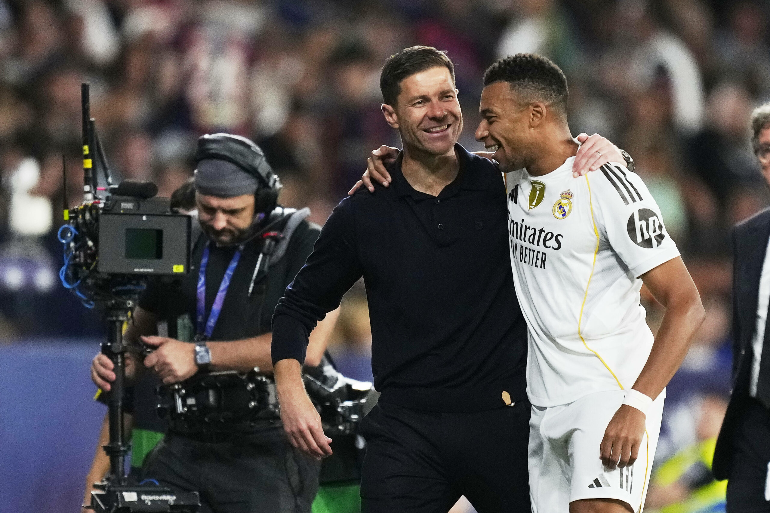 Real Madrids Trainer Xabi Alonso und Stürmer Kylian Mbappe liegen sich lachend in den Armen