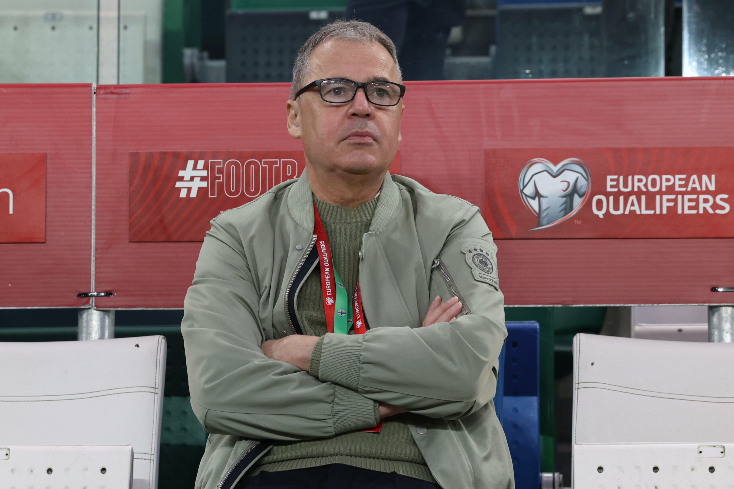 DFB-Geschäftsführer Andreas Rettig mit verschränkten Armen beim Spiel des DFB-Teams in Nordirland