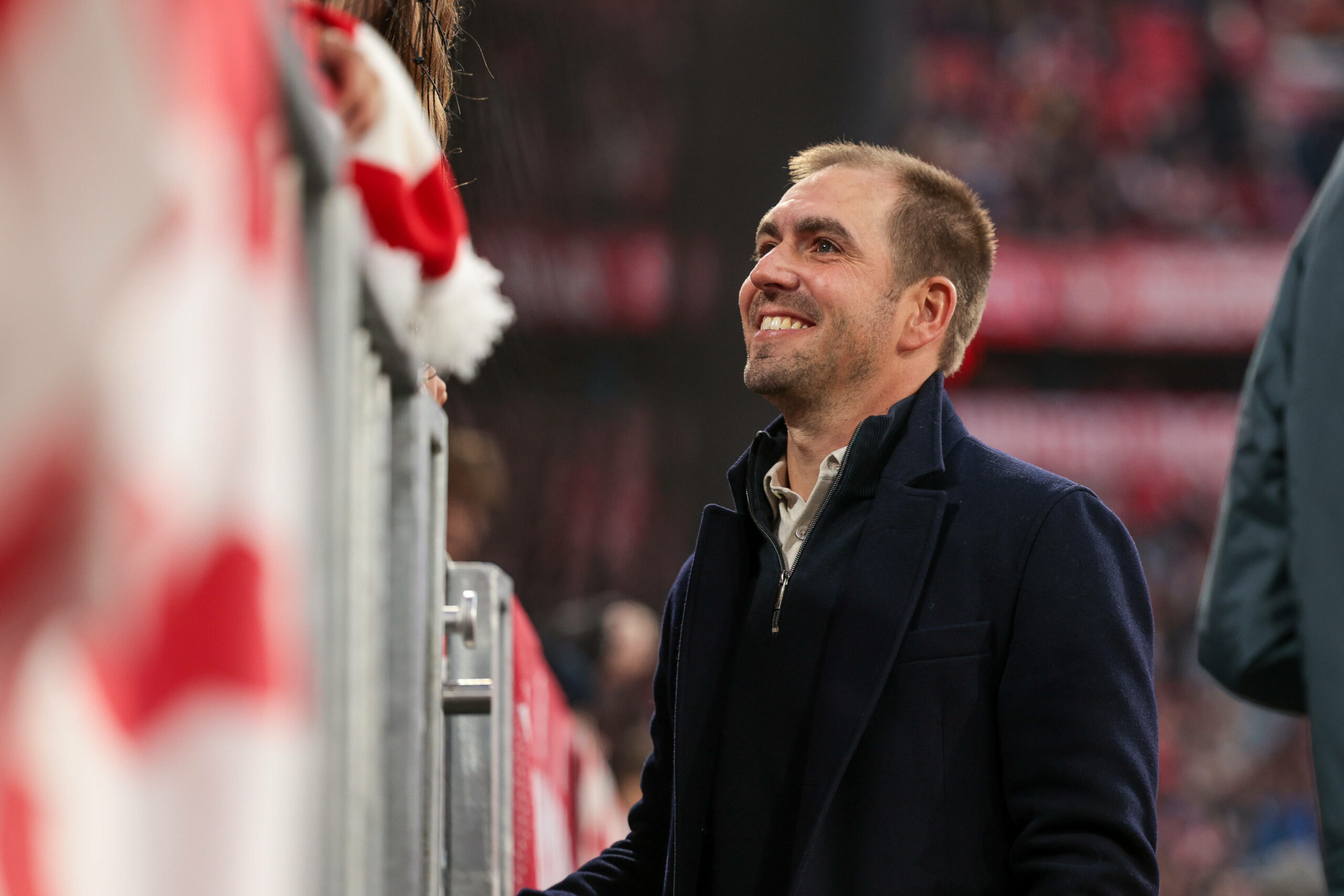 Philipp Lahm steht lächelnd in der Allianz Arena