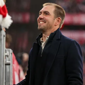 Philipp Lahm steht lächelnd in der Allianz Arena