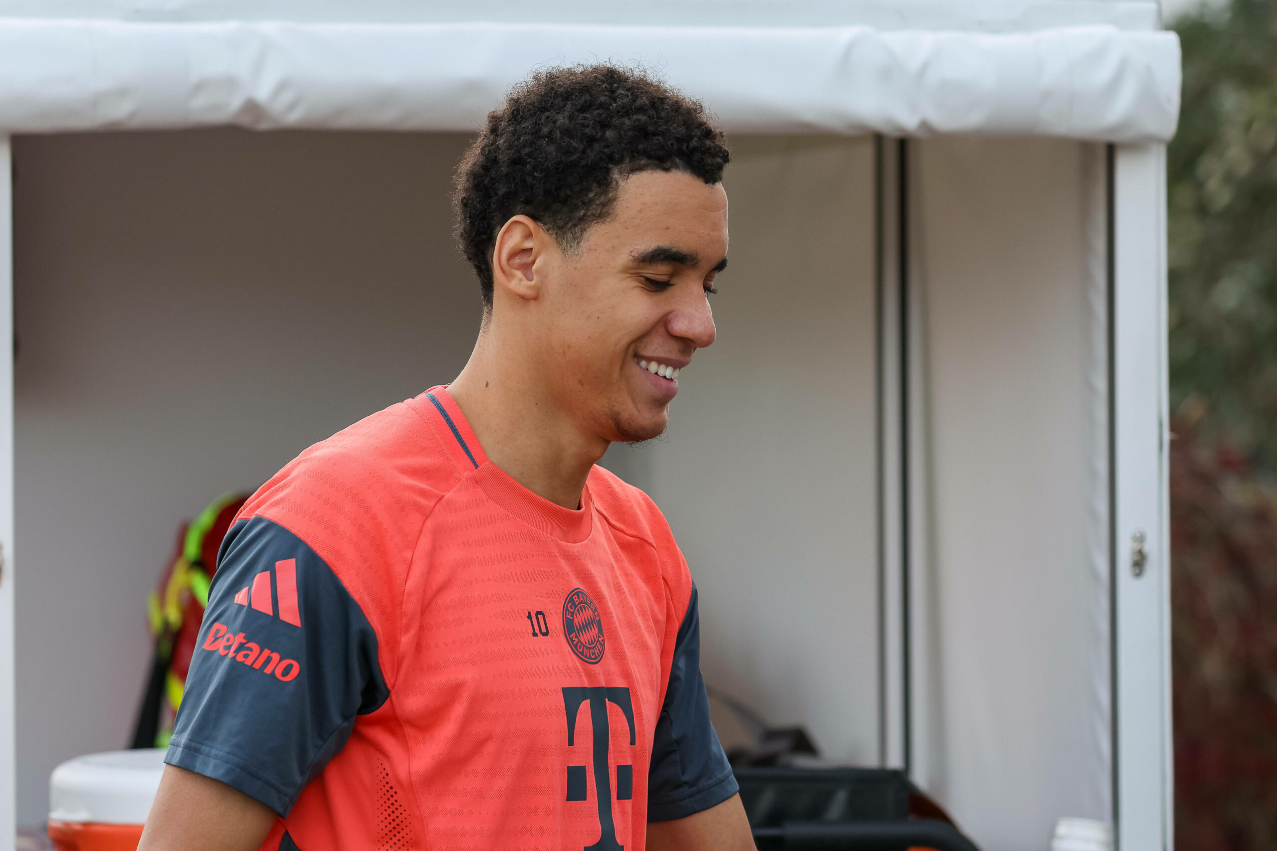 Ein lachender Jamal Musiala, Trainingsshirt des FC Bayern München