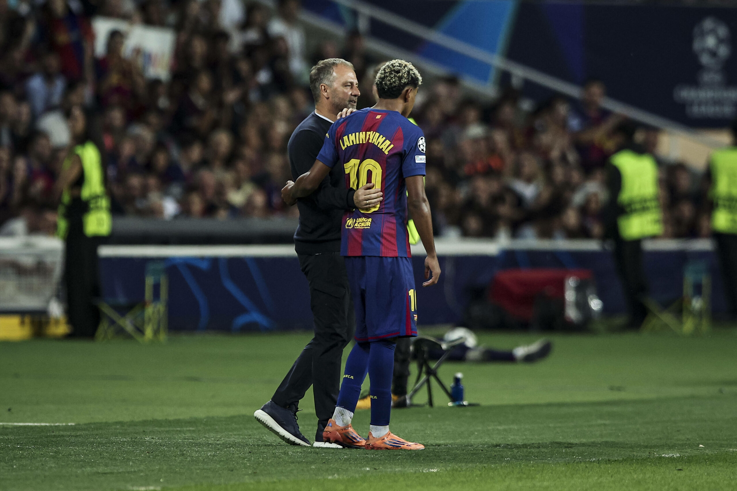 Hansi Flick (l.) nimmt Lamine Yamal (r.), vor einer Einwechslung in den Arm