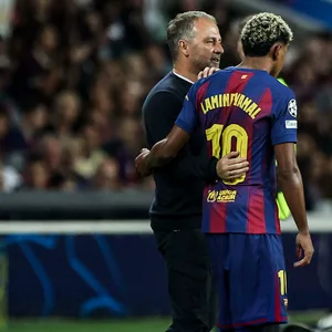 Hansi Flick (l.) nimmt Lamine Yamal (r.), vor einer Einwechslung in den Arm