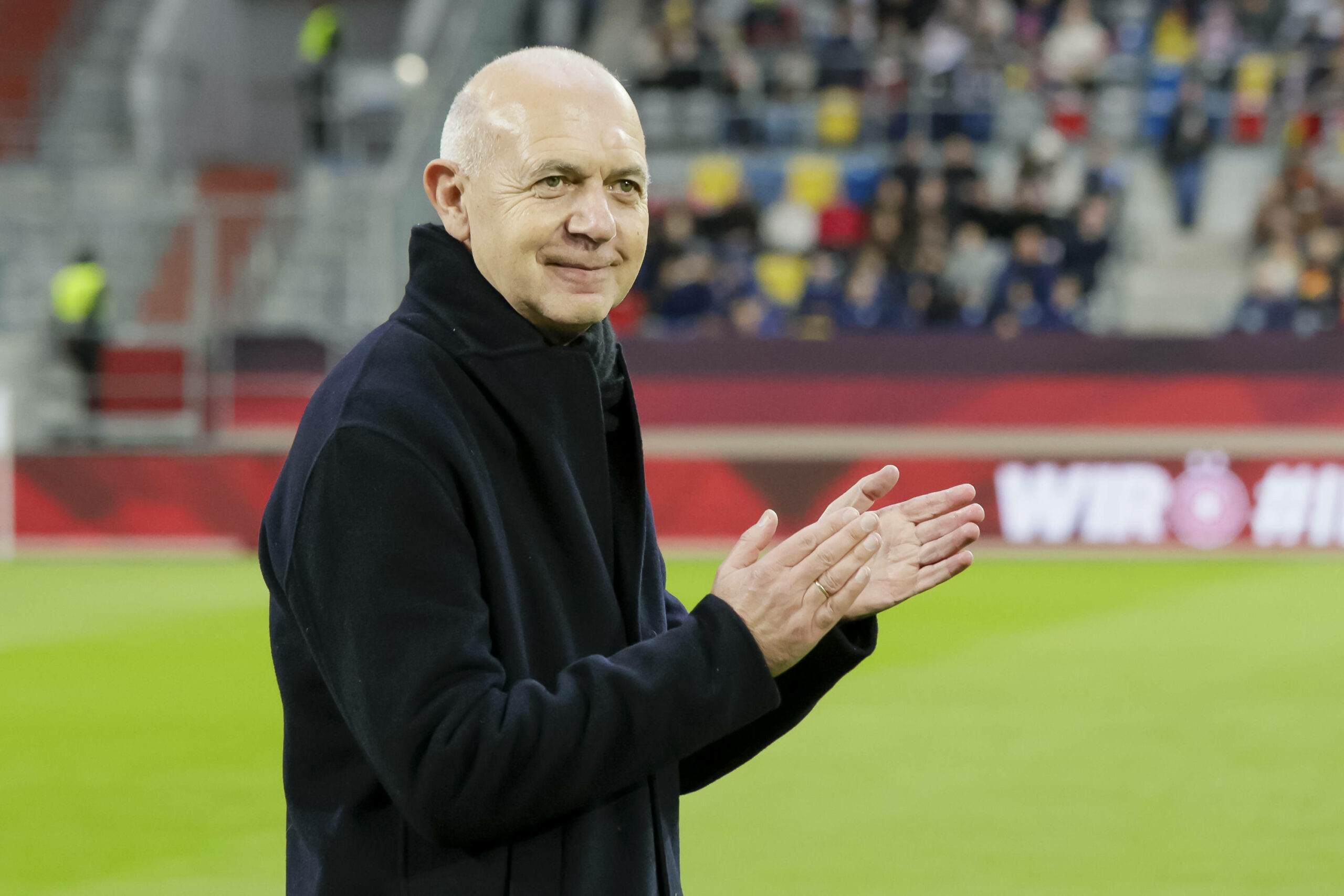 DFB-Präsident Bernd Neuendorf, lächelnd und applaudierend, im Stadion