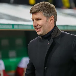 Thomas Hitzelsperger im Mantel in der WWK-Arena in Augsburg