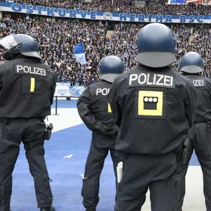 Polizisten stellen sich, im Innenraum, vor der Ostkurve des Olympiastadions auf