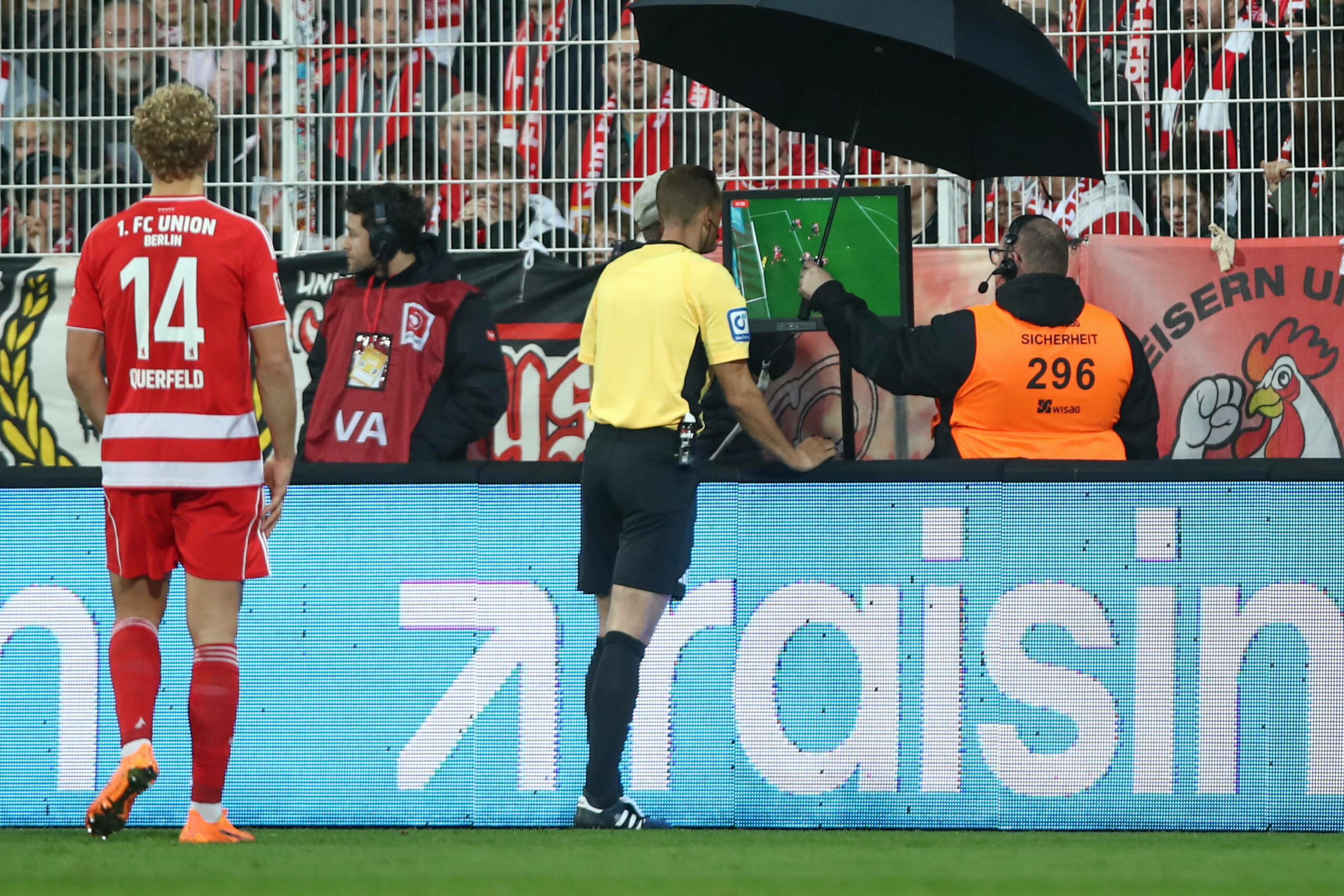 Leopold Querfeld (Union Berlin, l.) schaut Schiedsrichter Sören Storks beim VAR-Check über die Schulter