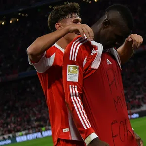 Tom Bischof (l.) jubelt gemeinsam mit Nicolas Jackson (r.), dieser zeigt, auf seinem Unterzieh-Shirt, eine Botschaft für einen verstorbenen Freund aus dem Senegal „RIP, My Bro Fokzo“