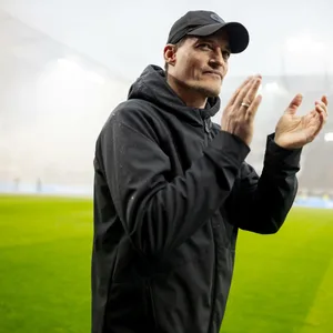 Alexander Blessin applaudiert, hinter ihm füllen Rauchschwaden das Millerntor.