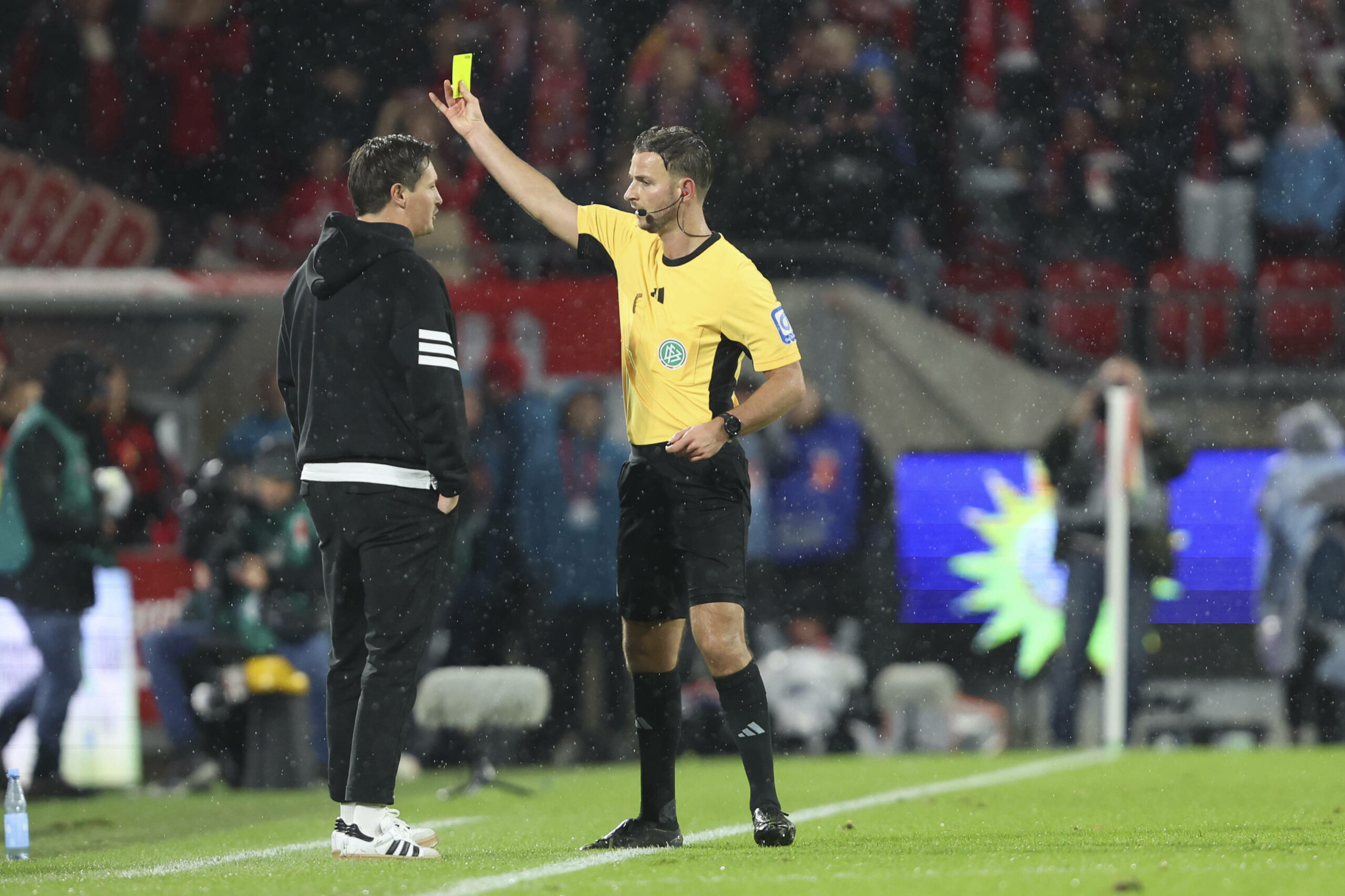 Schiedsrichter Daniel Schlager zeigt HSV-Trainer Merlin Polzin in Köln die Gelbe Karte.