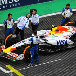 Mitarbeiter des Formel-1-Teams Racing Bulls stehen neben dem Auto, von Racing Bull Fahrer Liam Lawson, in der Startposition