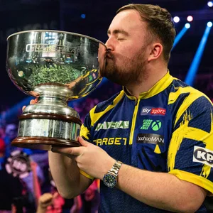 Luke Littler küsst den Pokal nach seinem Sieg beim Grand Slam of Darts
