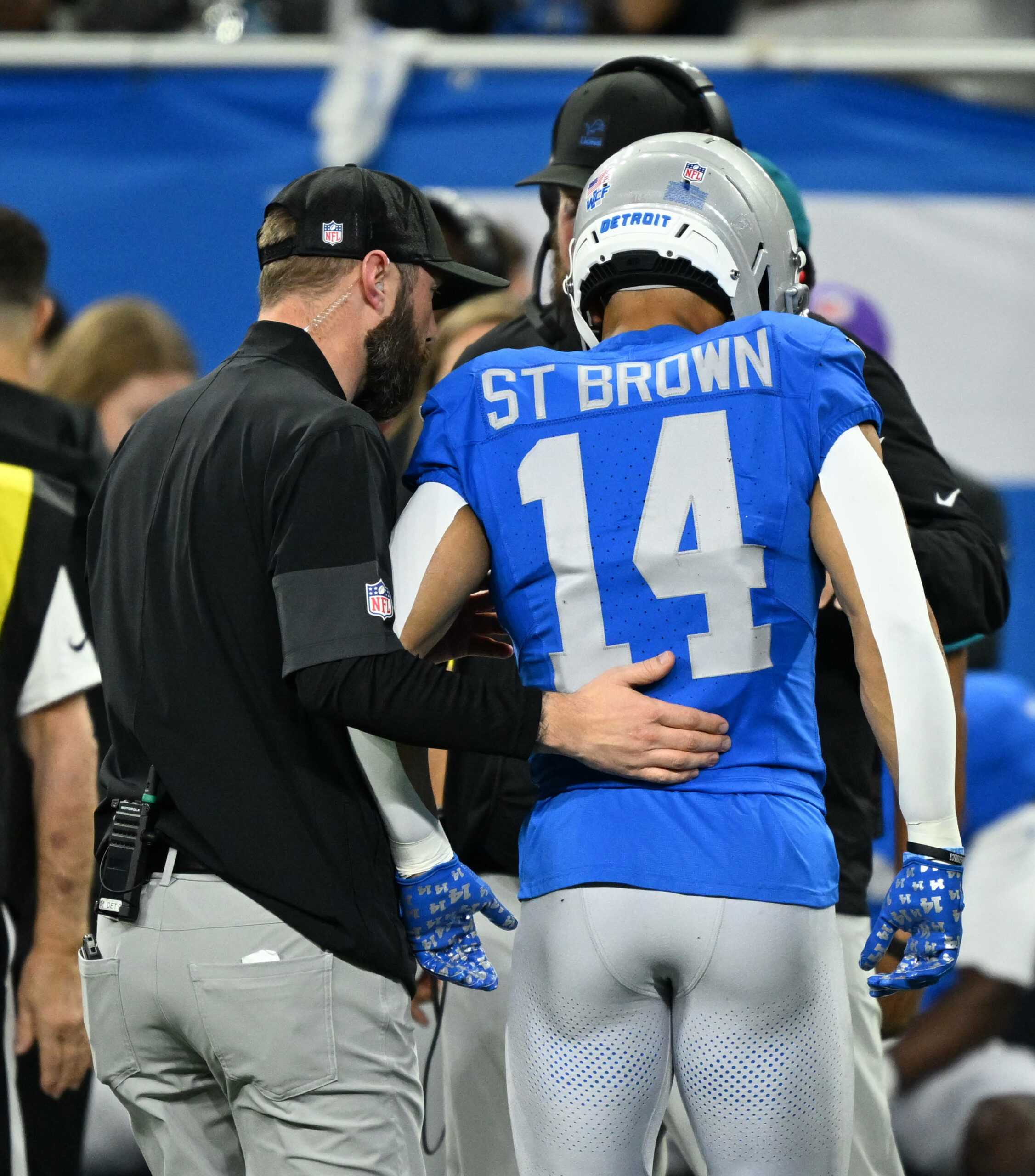 Amon-Ra St. Brown wird nach seiner Verletzung vom Feld geführt.