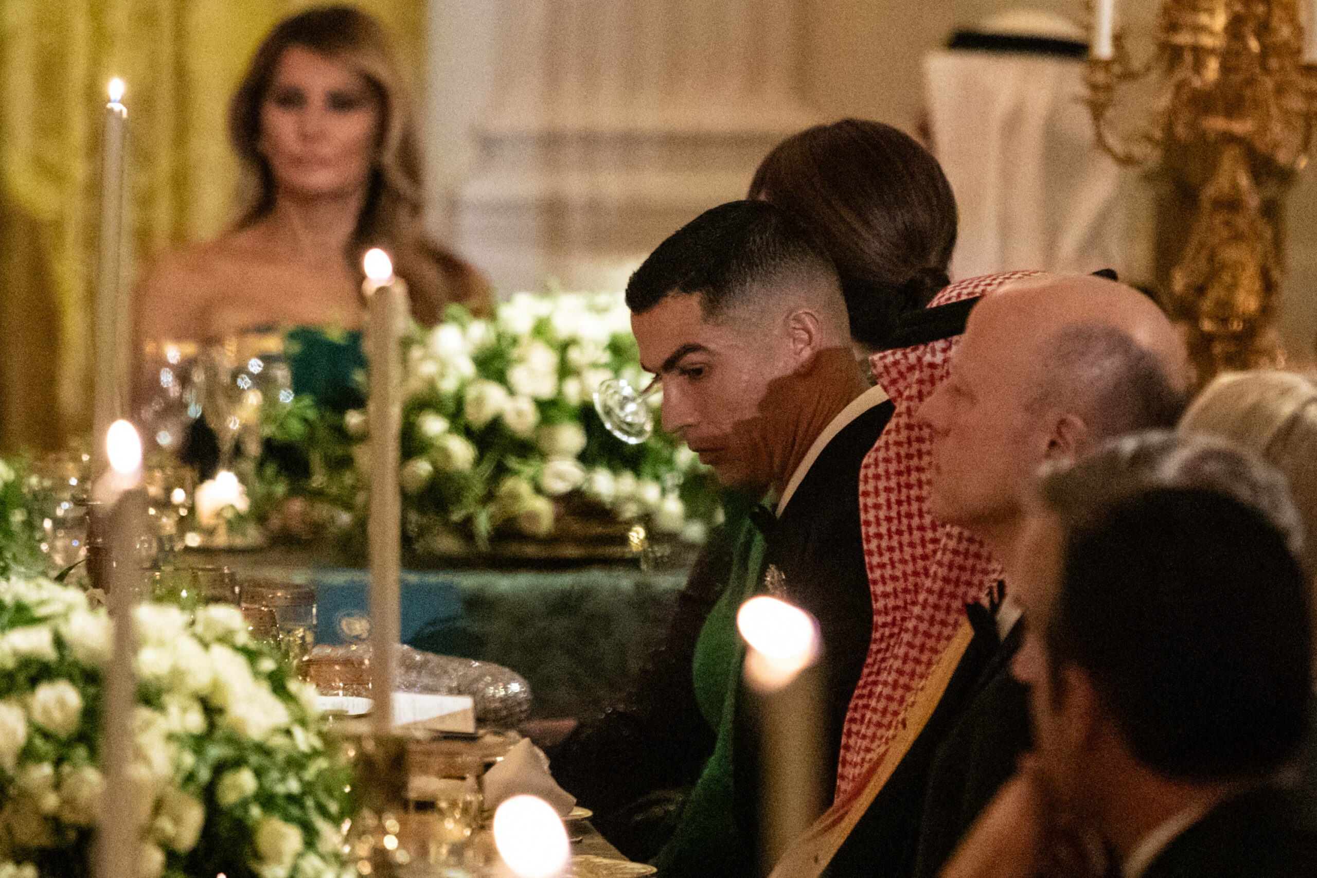 Superstar Cristiano Ronaldo sitzt bei einem von Donald Trump veranstalteten Abendessen im weißen Haus. Im Hintergrund sitzt die First Lady Melania Trump