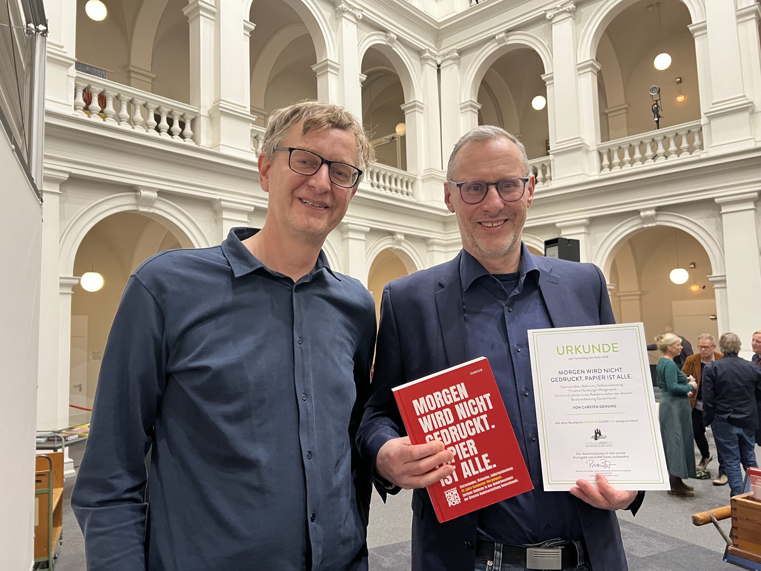 Autor Carsten Gensing (r.) und MOPO-Chefredakteur Maik Koltermann freuen sich über die Auszeichnung für die MOPO-Chronik.
