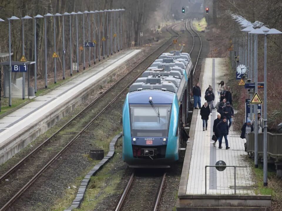 Menschen steigen aus einem Zug aus.