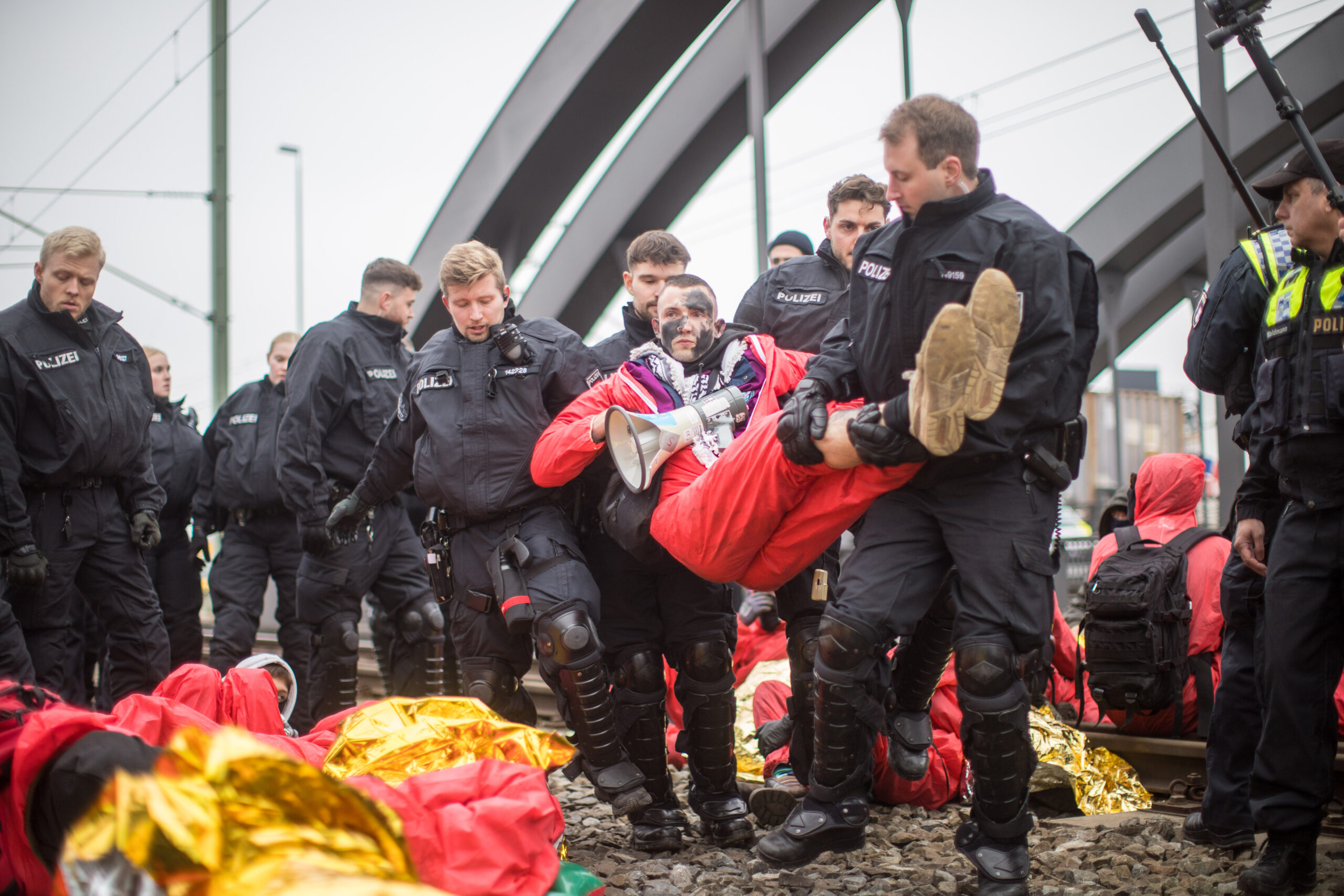 Polizisten tragen Teilnehmer der nicht angemeldeten Demo von den Gleisen.