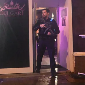 Ein Polizist mit Maschinenpistole sichert den Eingang einer Kneipe.