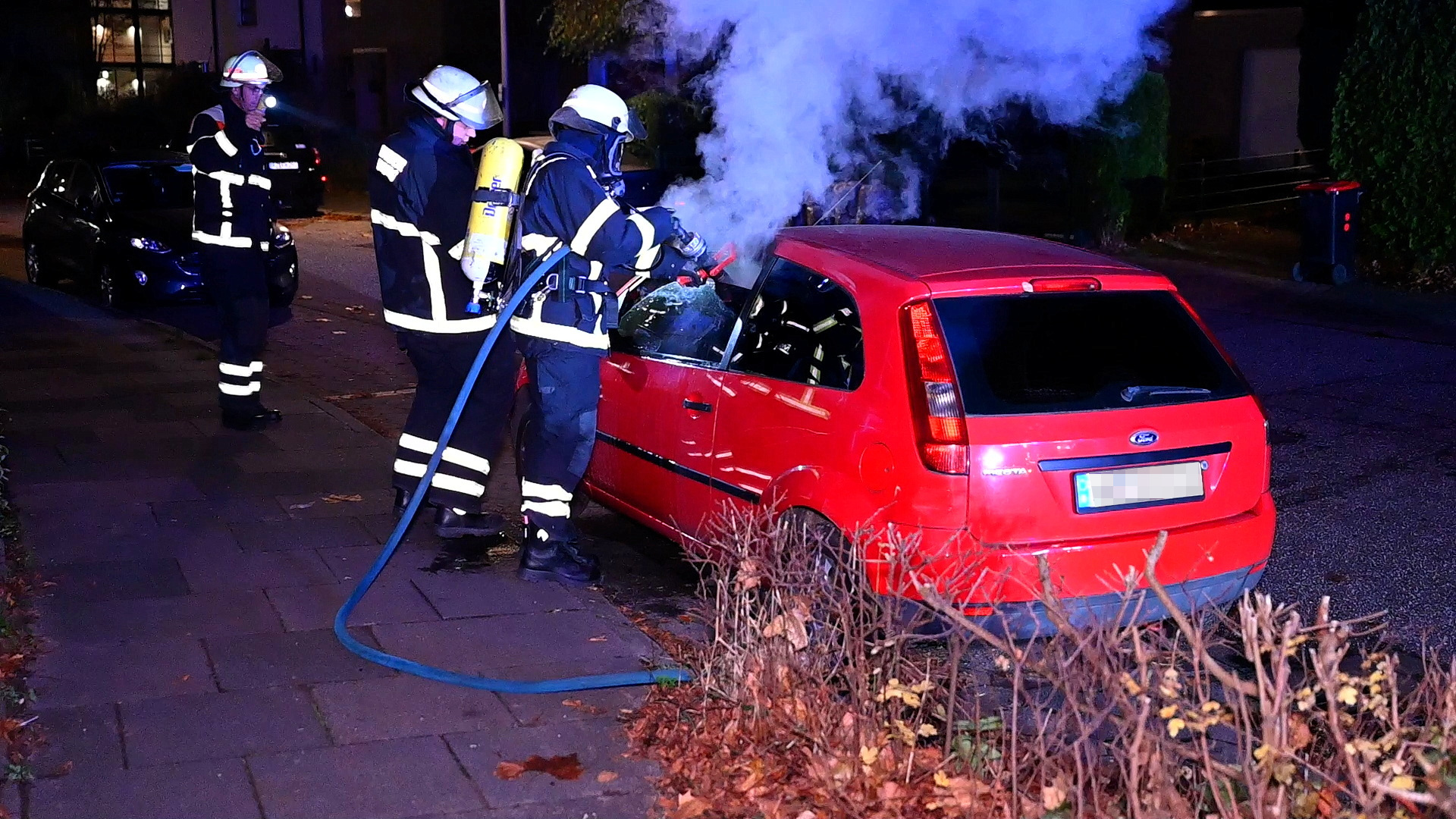 Brand in Hamburg-Rahlstedt: Feuerwehrleute löschen den Wagen am Hauke-Haien-Weg.