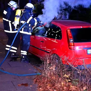 Brand in Hamburg-Rahlstedt: Feuerwehrleute löschen den Wagen am Hauke-Haien-Weg.