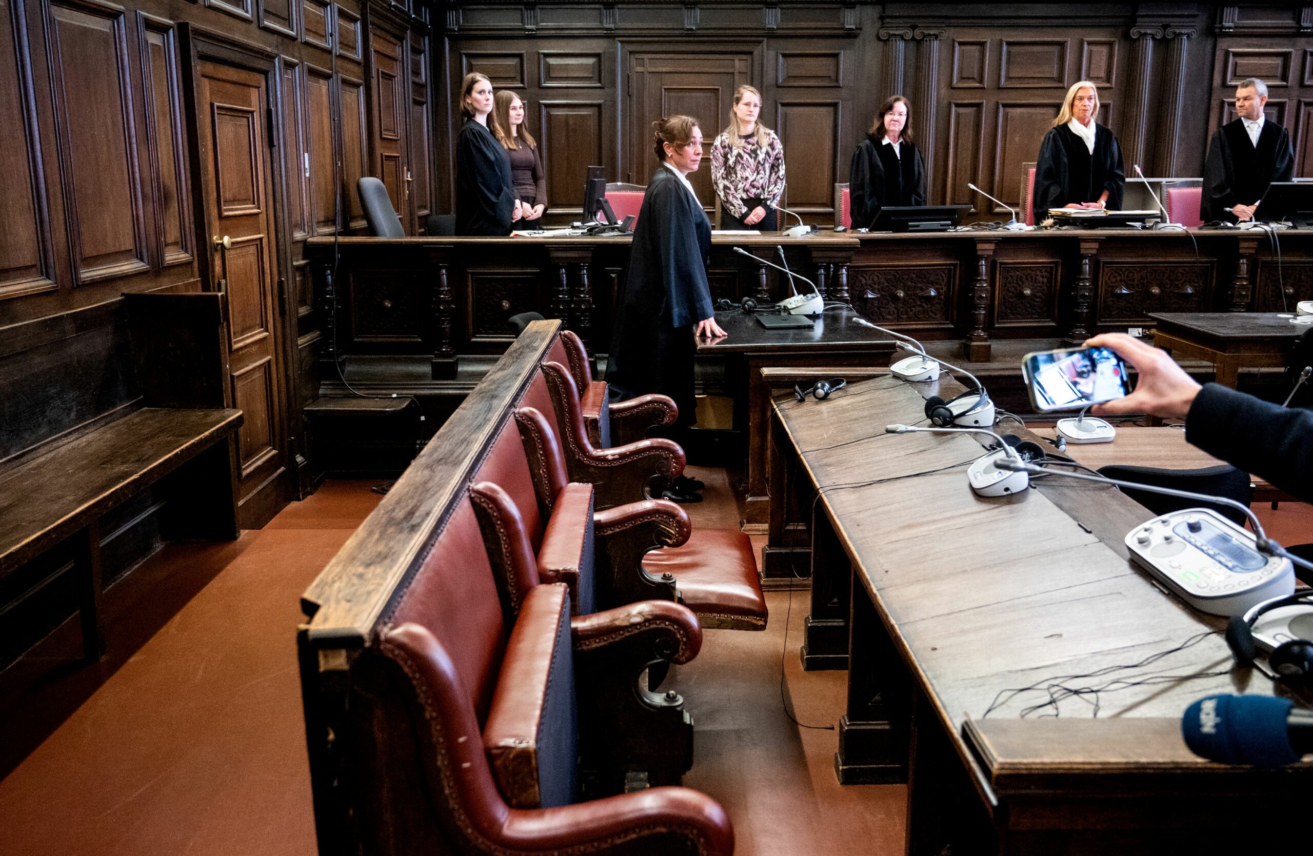Katharina Gieseking, (vorne, M.), Anwältin der Angeklagten, steht im Landgericht im Sitzungssaal ohne ihre Mandantin. Birgit Woitas (2.v.r.) ist die Vorsitzende Richterin am Landgericht.