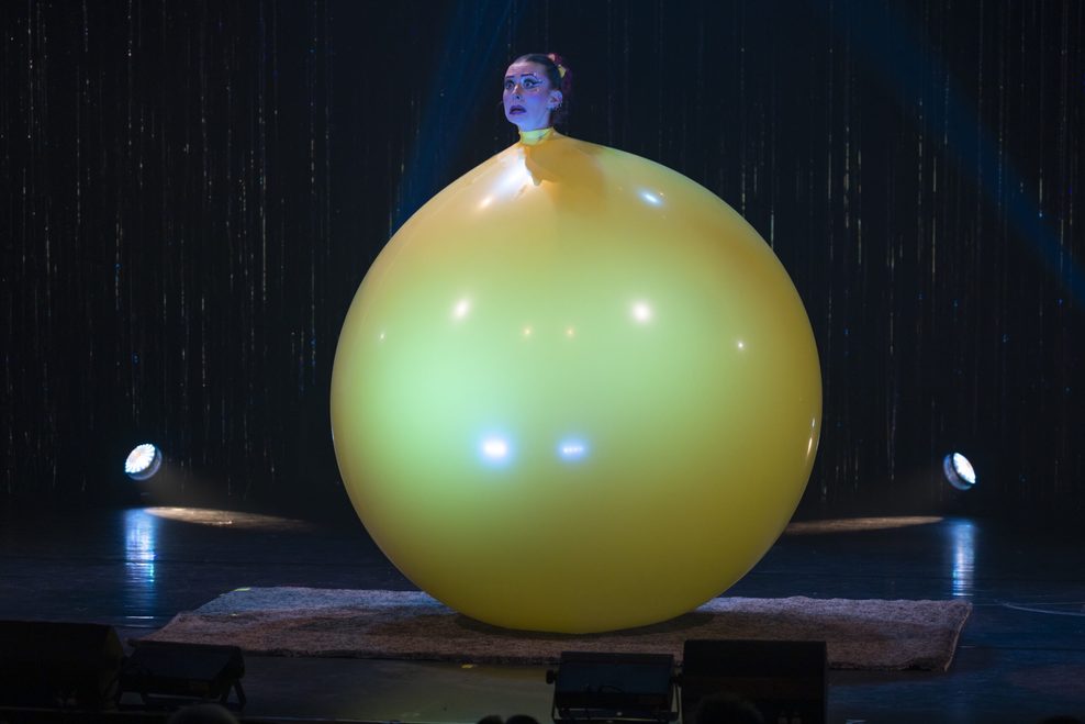 Eine Akrobatik-Künstlerin in einem Riesenballon