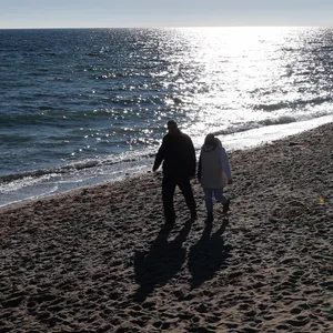 Menschen sind bei strahlendem Sonnenschein und frostigen Temperaturen an der Schönhagener Steilküste an der Ostsee unterwegs.
