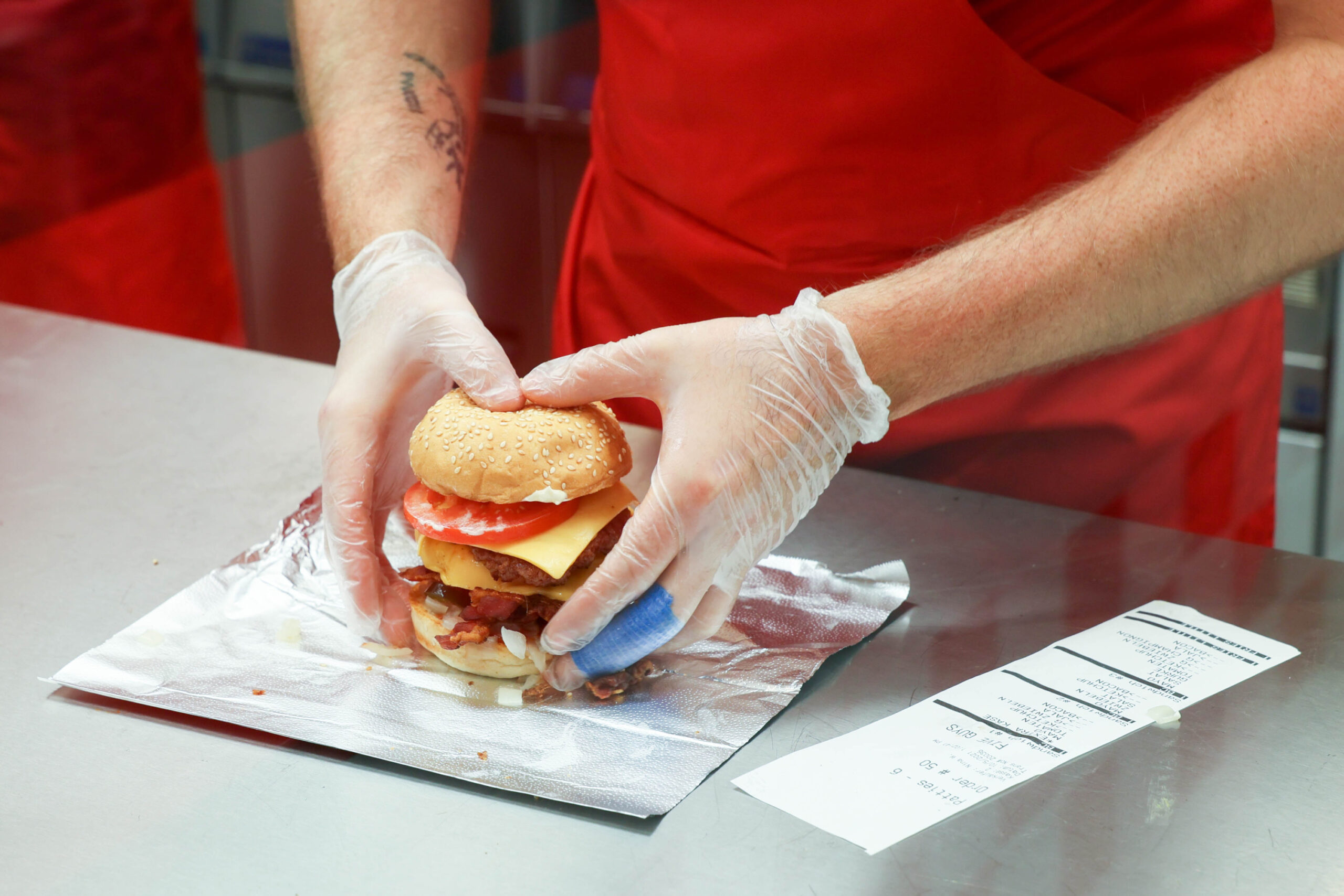 Ein Five Guys-Mitarbeiter bereitet einen Burger zu.