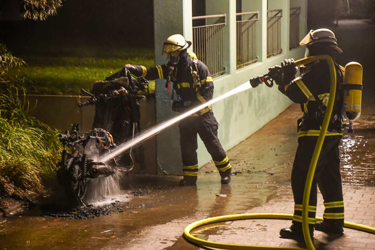 Feuerwehrkräfte löschen den Roller.
