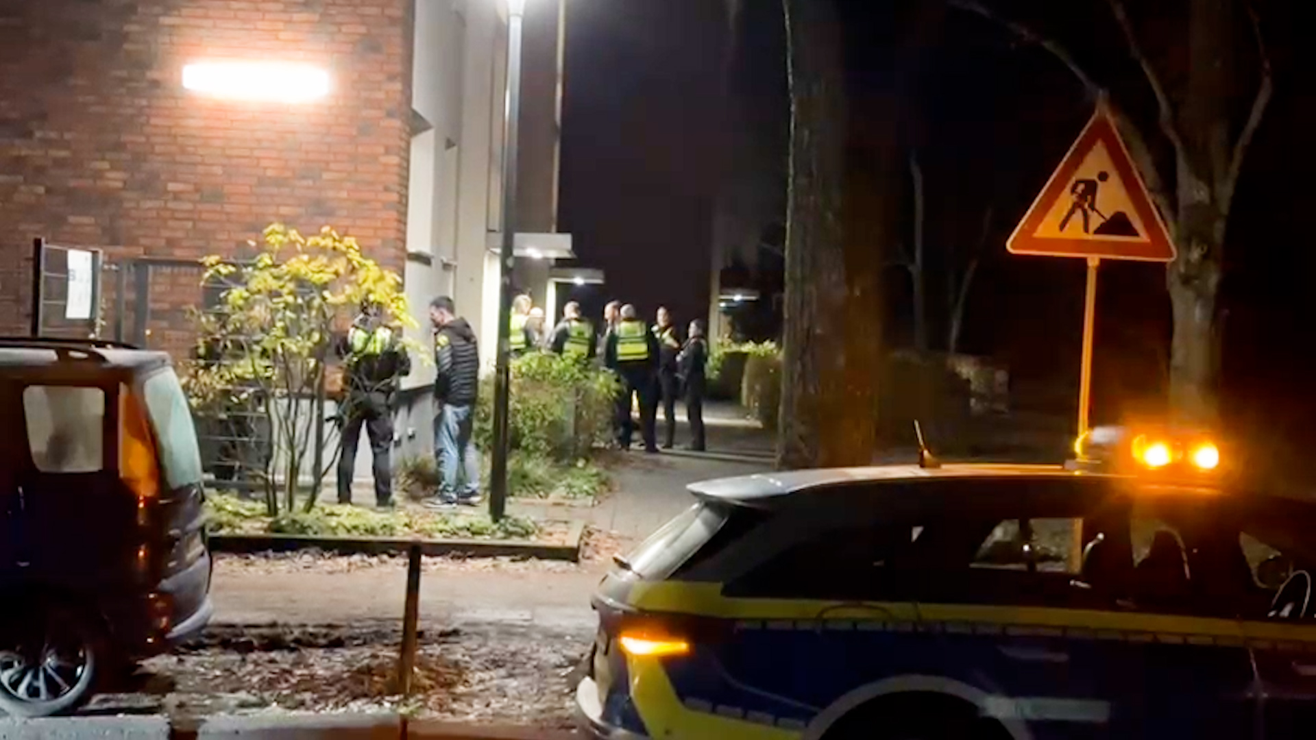 Polizisten stehen vor dem Haus in der Legienstraße.