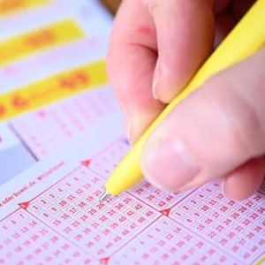 Eine Frau füllt einen Lottoschein aus.