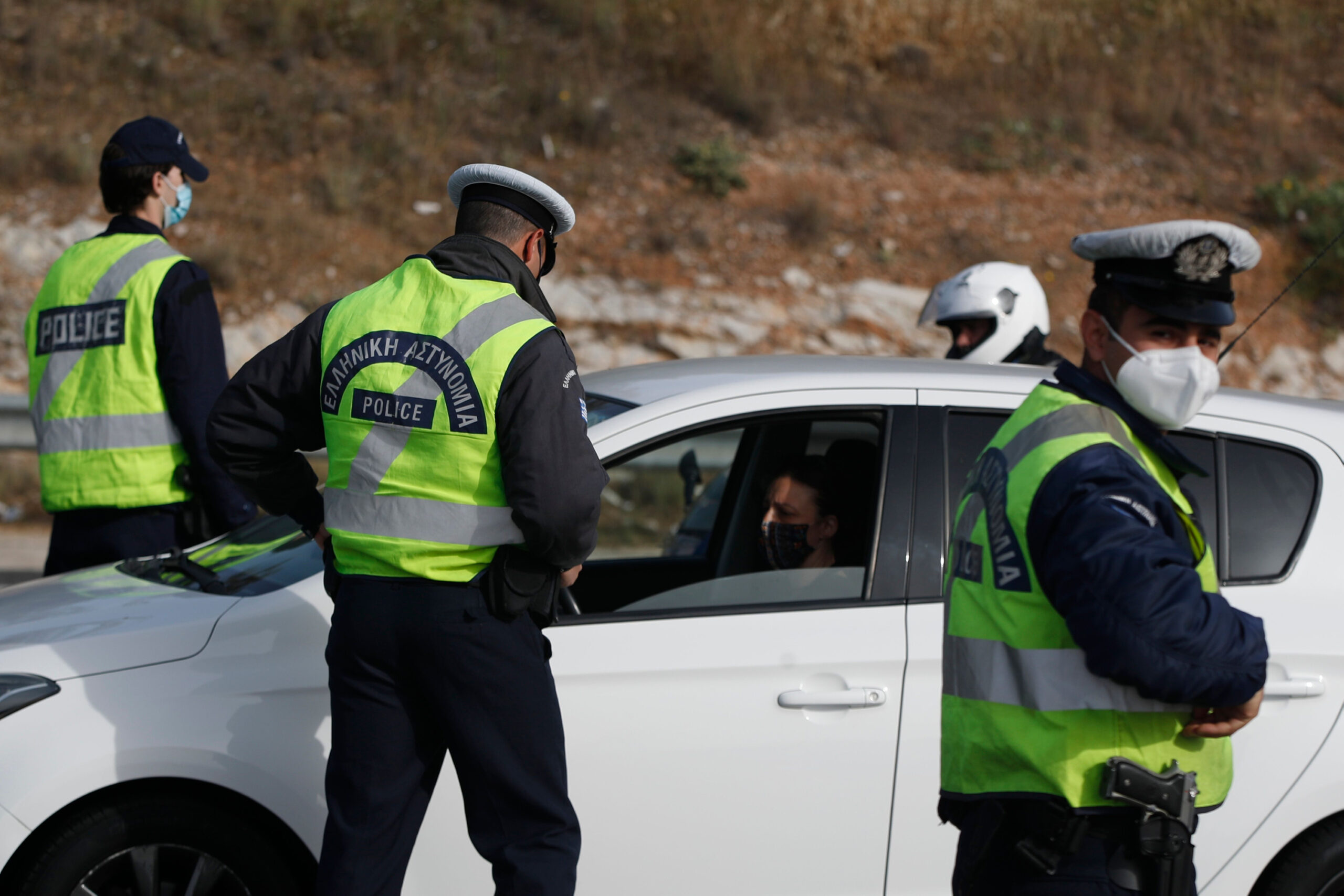 Polizisten überprüfen auf Kreta die Fahrer auf gültige Dokumente an einer Straßensperre.